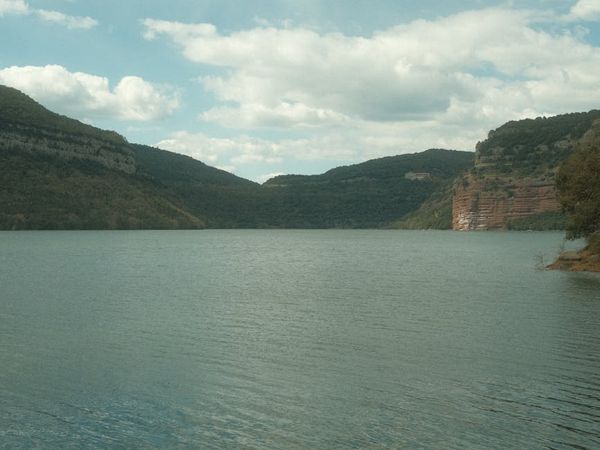 Serene landscape with a calm lake and green hills.